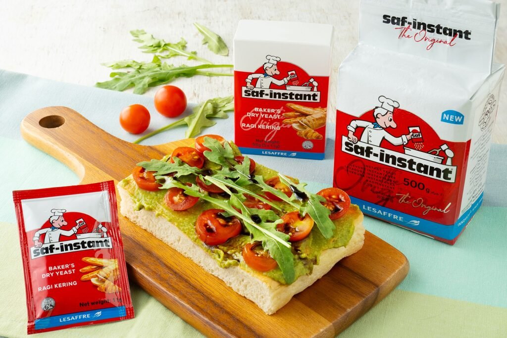 Avocado focaccia with cherry tomatoes and rocket on a board, with Saf-instant yeast