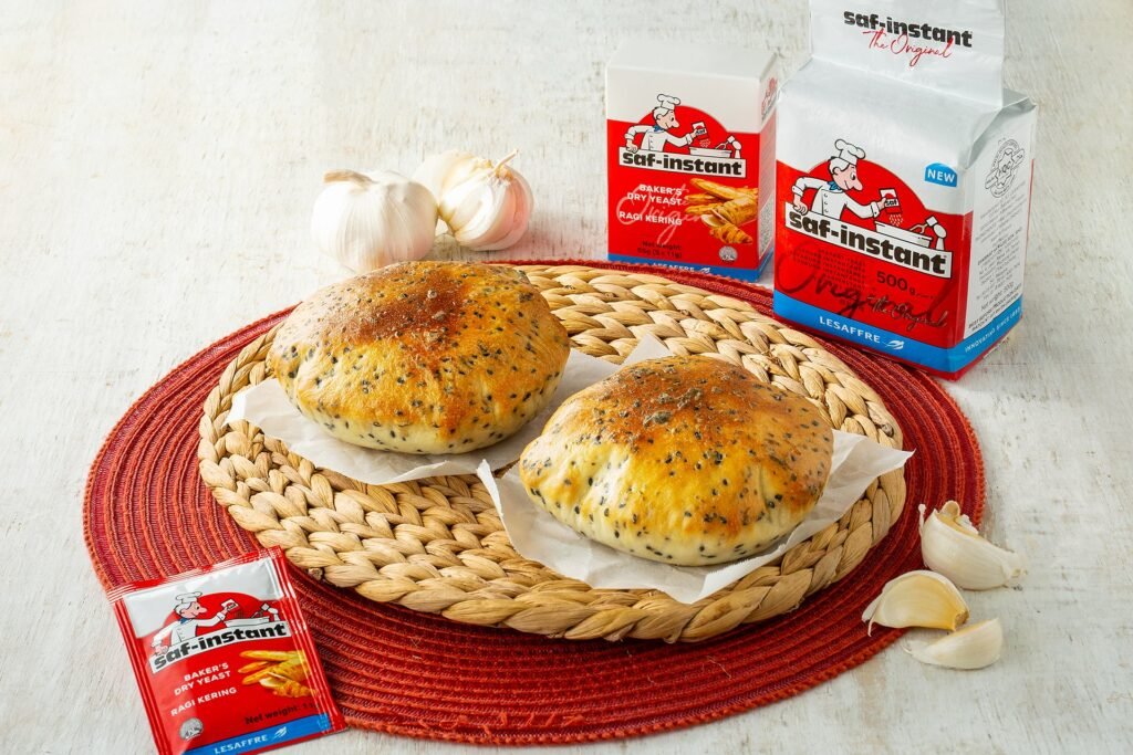 Garlic butter black sesame pita breads on a woven mat with garlic