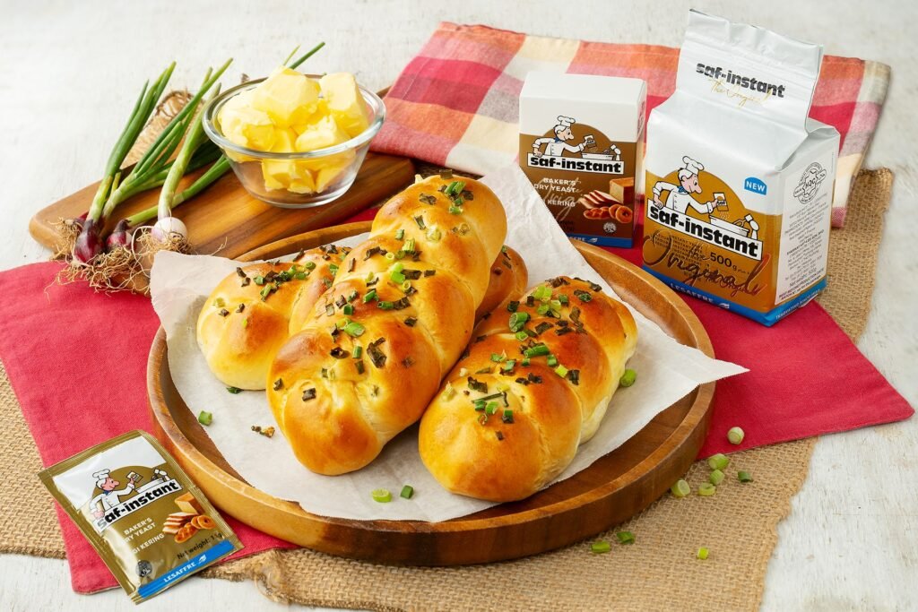 Scallion plait buns on a wooden board with butter and spring onions