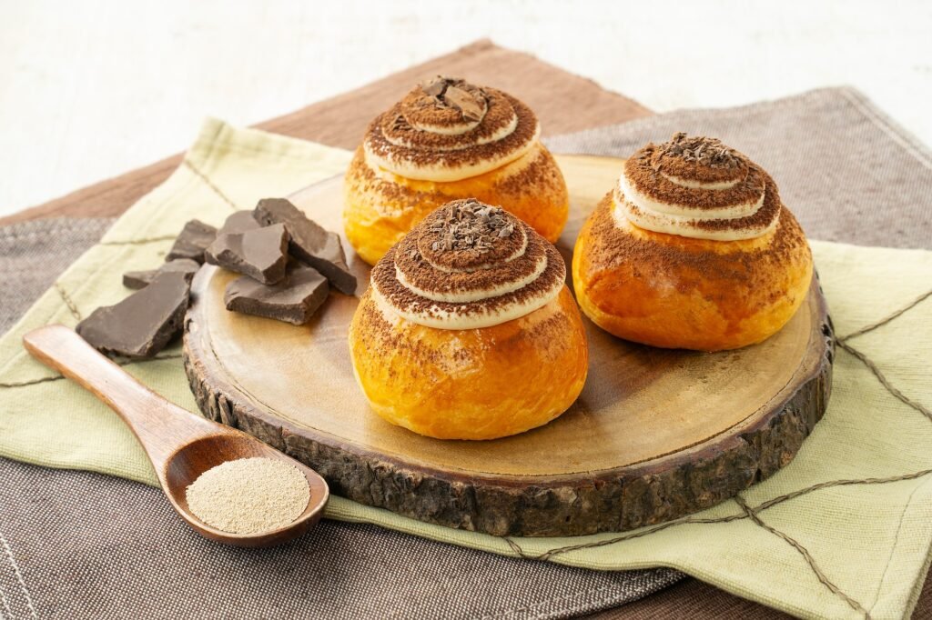 Tiramisu brioche buns with chocolate on a wooden board