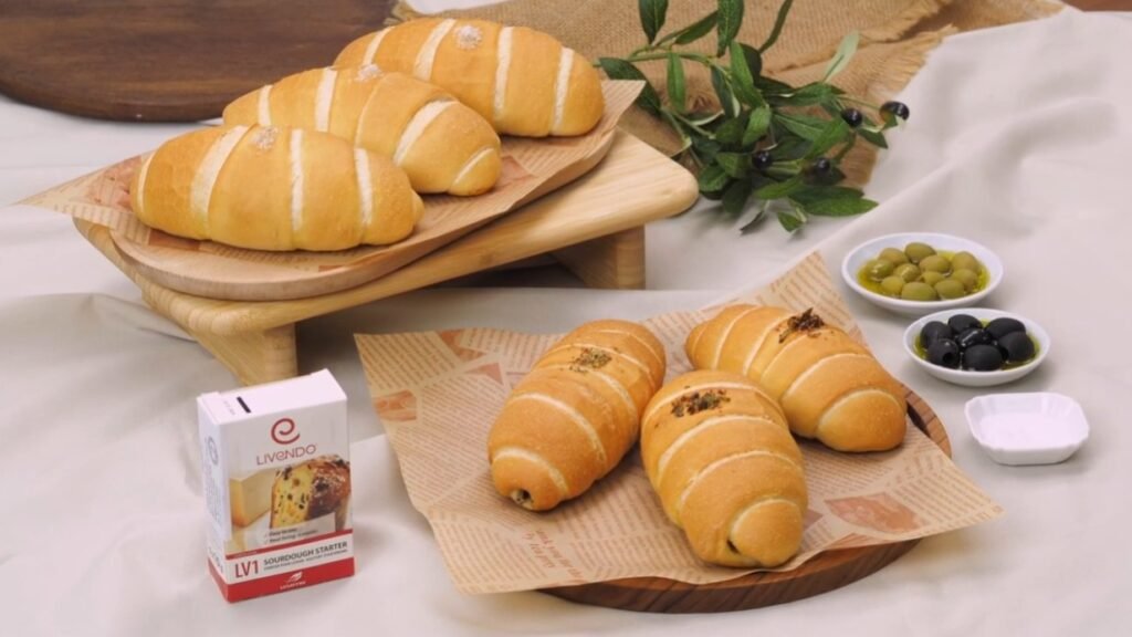 Soft bread rolls styled with olives and a Livendo LV1 sourdough starter pack