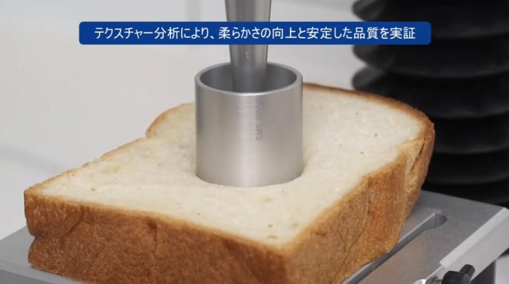 Japanese-language still of a texture analyser testing bread softness
