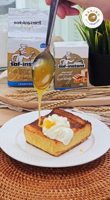 Honey drizzled over honey butter toast with whipped cream, with Saf-instant yeast packs